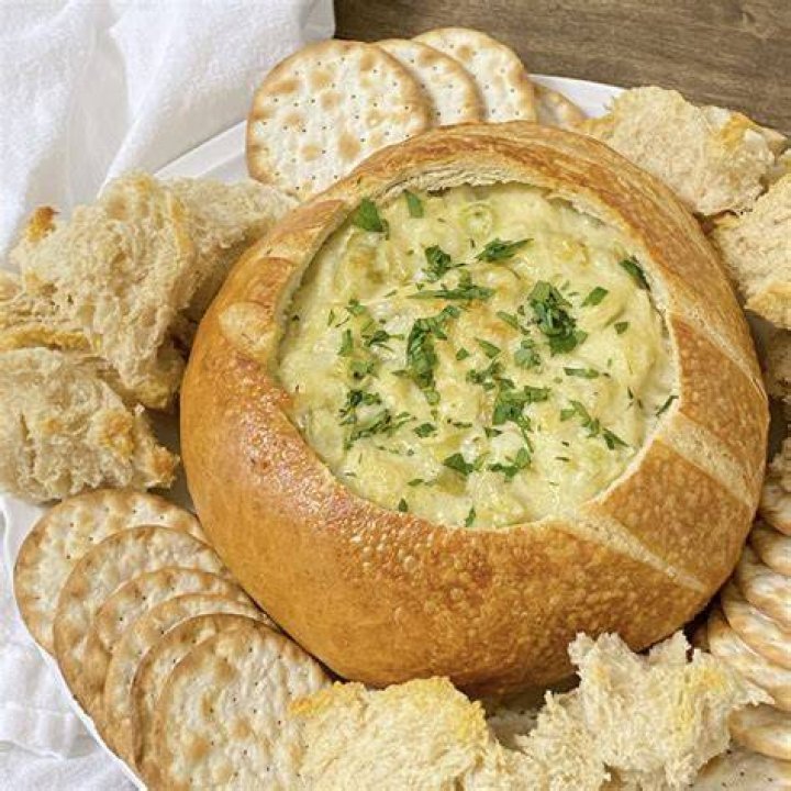 Bowl of artichoke dip with pita chips.