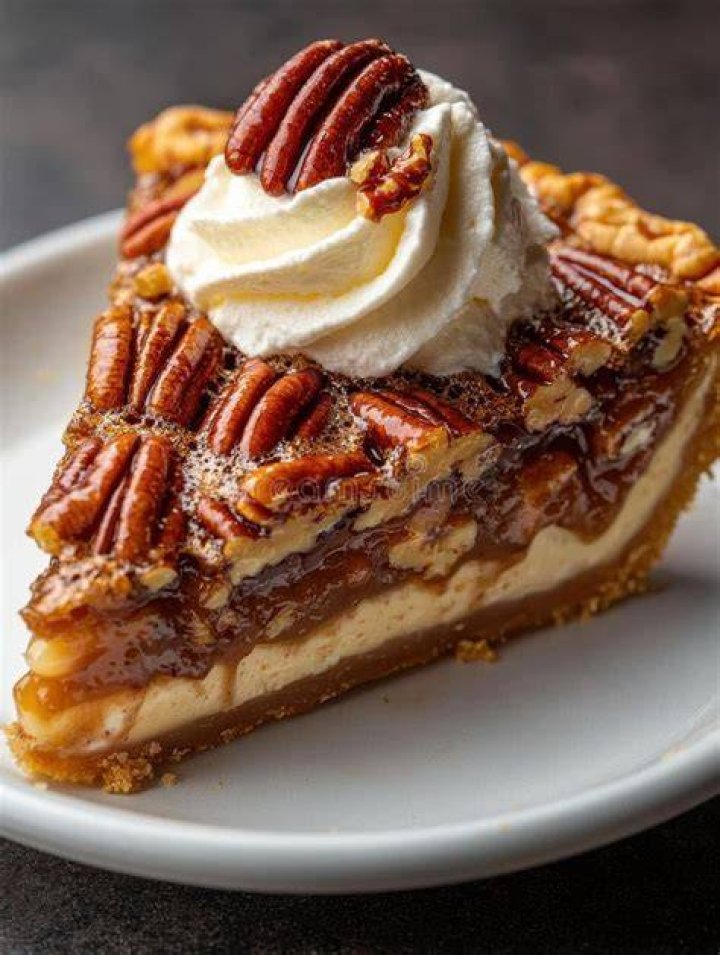 Slice of Pecan Pie topped with vanilla ice cream and chopped pecans.