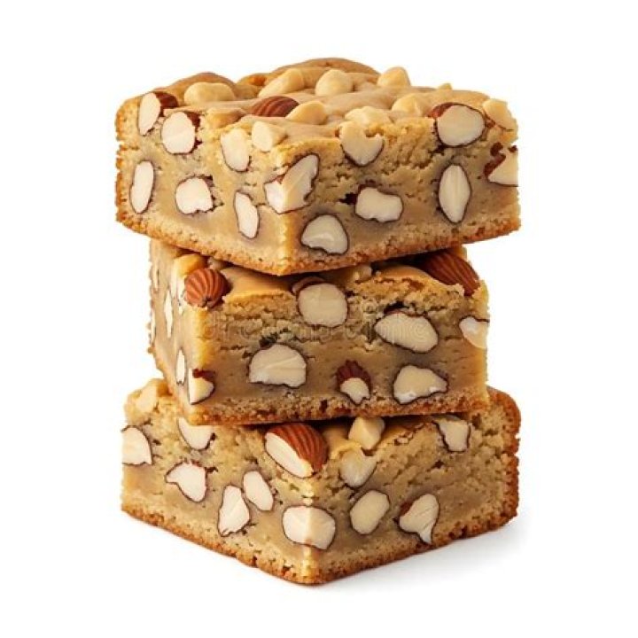 Stack of three blondie bars on parchment paper. 